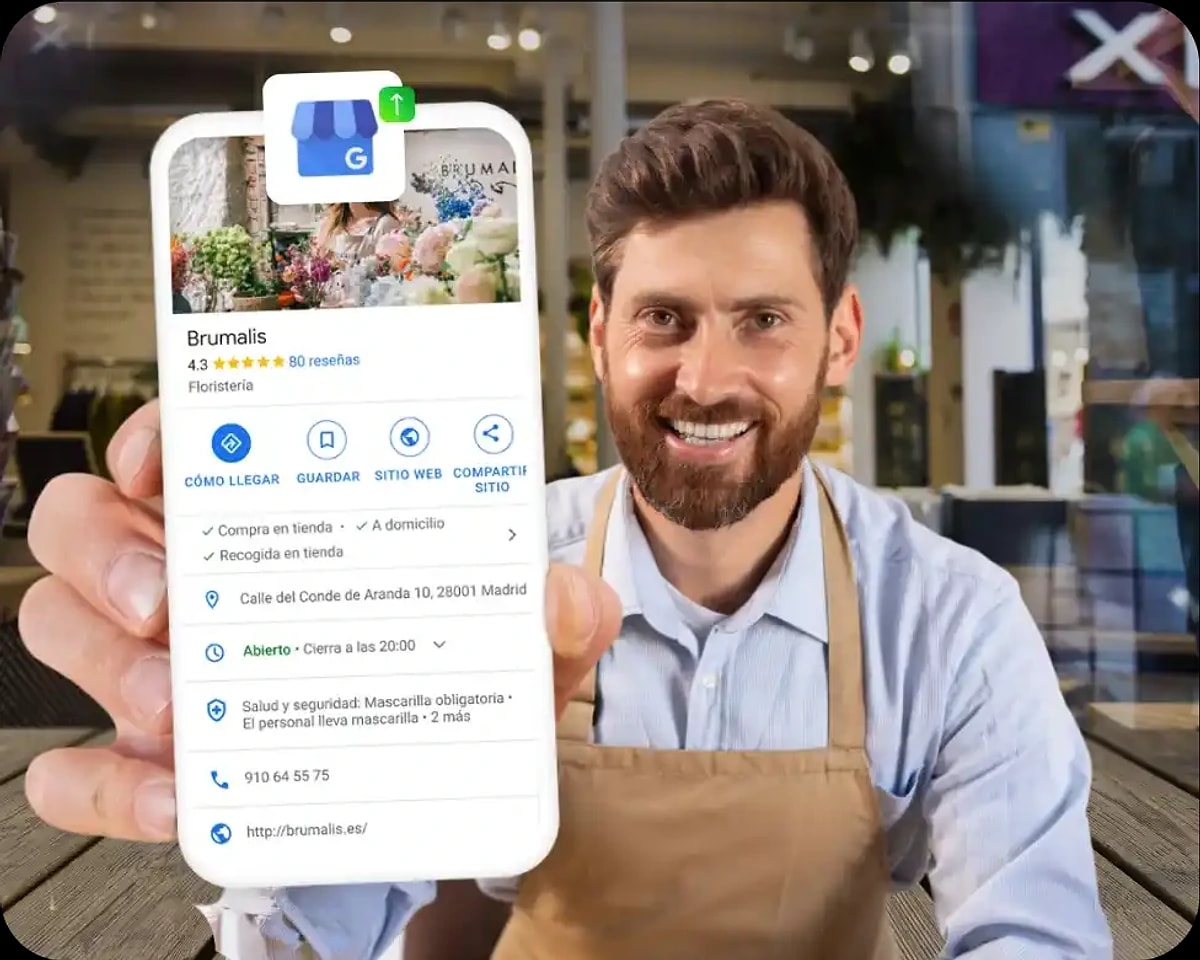 A smiling shop owner holding a phone showing their live Google Business Profile