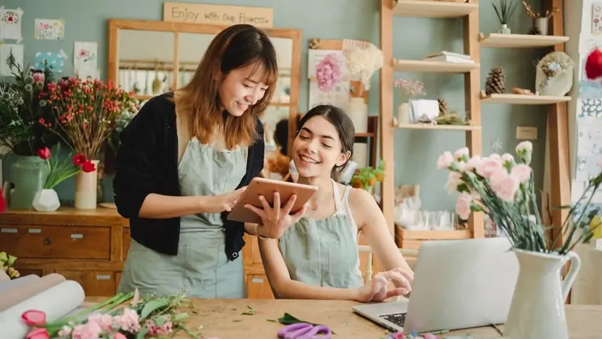 Two shop owners reviewing their reinstatement case on a tablet